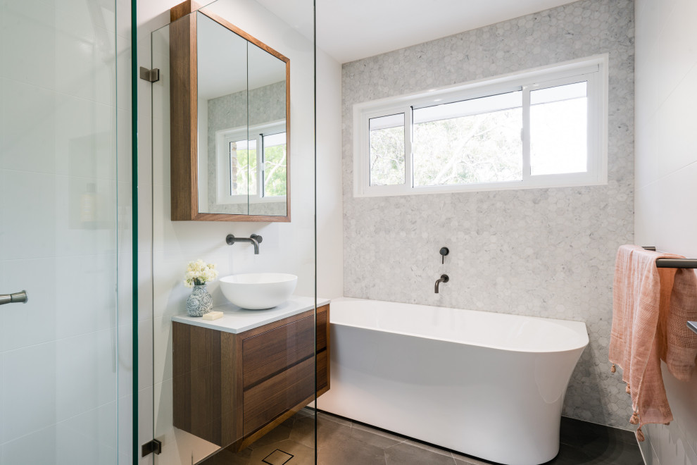 Design ideas for a contemporary bathroom in Sydney with flat-panel cabinets, dark wood cabinets, a freestanding tub, gray tile, an undermount sink, grey floor and white benchtops.