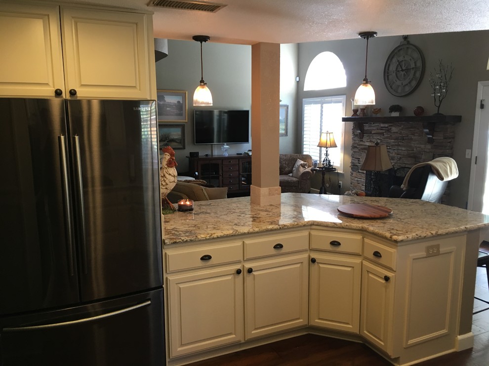 Trendy eat-in kitchen photo with raised-panel cabinets and beige cabinets