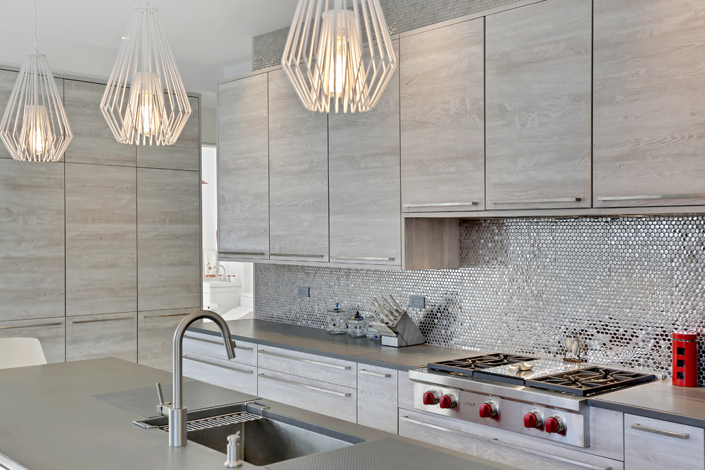 Mid-sized minimalist l-shaped concrete floor and gray floor eat-in kitchen photo with a drop-in sink, flat-panel cabinets, gray cabinets, quartzite countertops, gray backsplash, mosaic tile backsplash, stainless steel appliances and an island