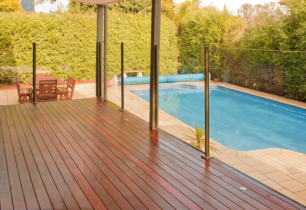 Photo of a large modern backyard deck in Sydney with a water feature and a pergola.