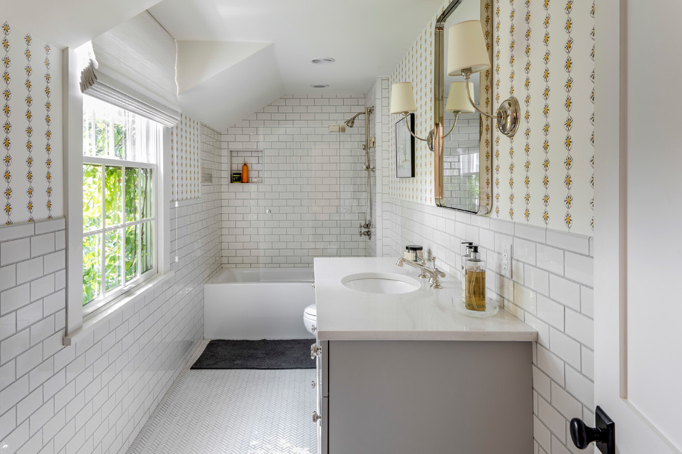 Inspiration for a large beach style 3/4 bathroom in Boston with grey cabinets, an alcove tub, a shower/bathtub combo, white tile, white walls, an undermount sink, white floor and a sliding shower screen.