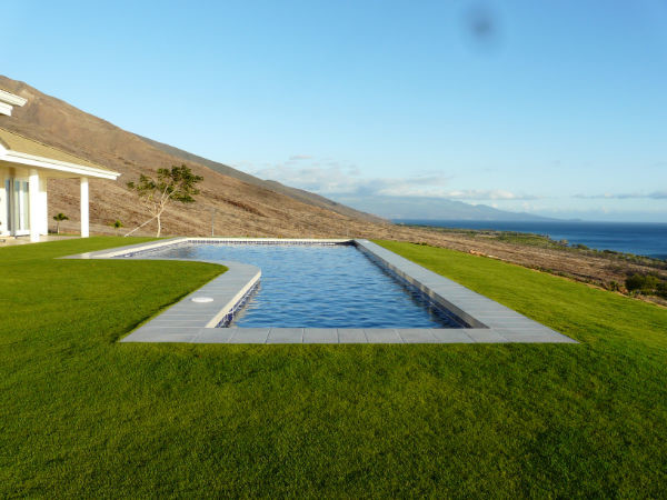 Large backyard concrete paver and l-shaped lap water slide photo