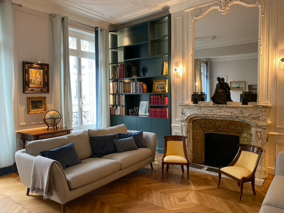 Großes, Repräsentatives, Offenes Klassisches Wohnzimmer in grau-weiß mit blauer Wandfarbe, hellem Holzboden, Kamin, Kaminumrandung aus Stein und Kassettendecke in Paris