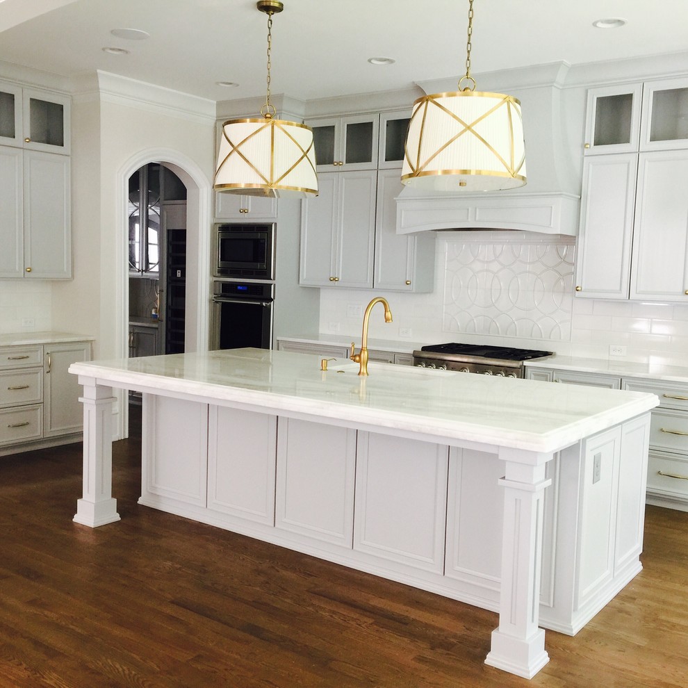 Photo of a large traditional open plan kitchen in Raleigh with a farmhouse sink, glass-front cabinets, grey cabinets, marble benchtops, white splashback, ceramic splashback, panelled appliances, dark hardwood floors and with island.