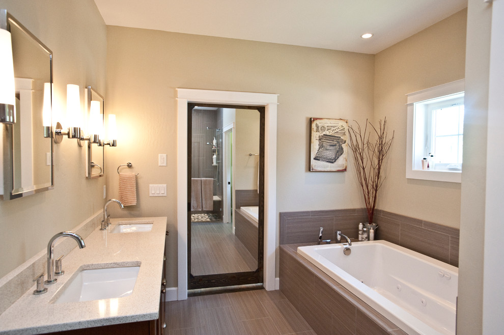 Example of a large transitional master gray tile and ceramic tile ceramic tile drop-in bathtub design with an undermount sink, shaker cabinets, quartz countertops, gray walls and dark wood cabinets