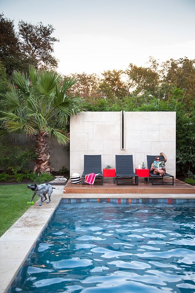 Contemporary backyard rectangular pool in Austin with decking.