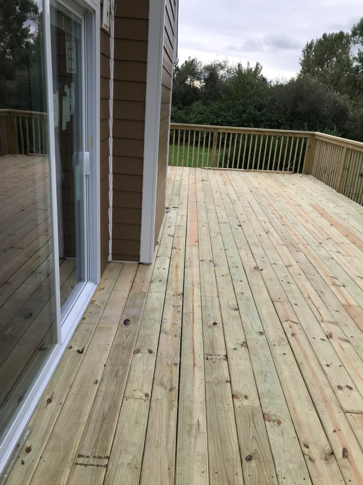 Large transitional backyard deck photo with no cover