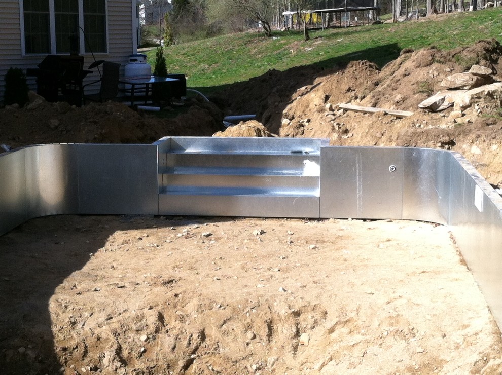 Example of a mid-sized backyard brick and rectangular pool design