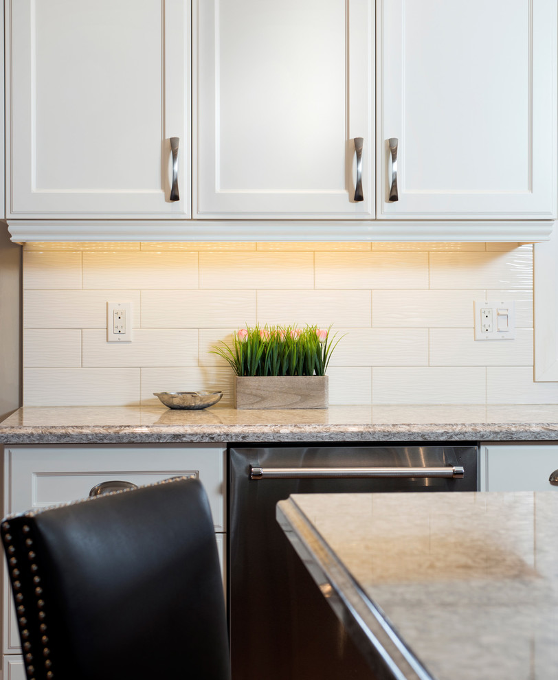 Large transitional l-shaped medium tone wood floor kitchen photo in Toronto with an undermount sink, recessed-panel cabinets, white cabinets, quartz countertops, white backsplash, subway tile backsplash, stainless steel appliances and an island