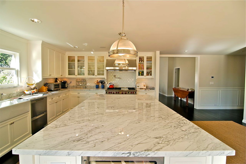Photo of an arts and crafts kitchen in Los Angeles with a farmhouse sink, shaker cabinets, white cabinets, marble benchtops and stainless steel appliances.