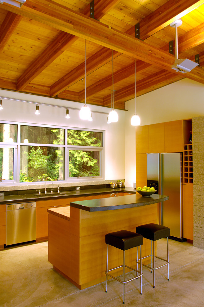 Inspiration for a contemporary eat-in kitchen in Seattle with stainless steel appliances, flat-panel cabinets, medium wood cabinets, with island and grey floor.