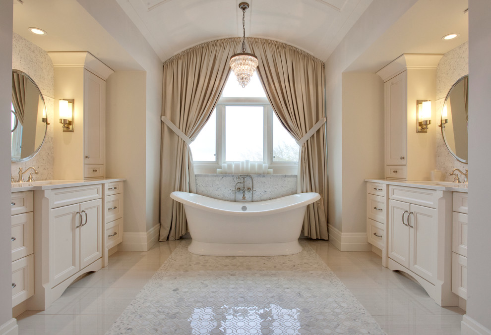 Inspiration for a large master bathroom in Calgary with an undermount sink, raised-panel cabinets, beige cabinets, granite benchtops, a freestanding tub, beige tile, ceramic tile, beige walls and ceramic floors.