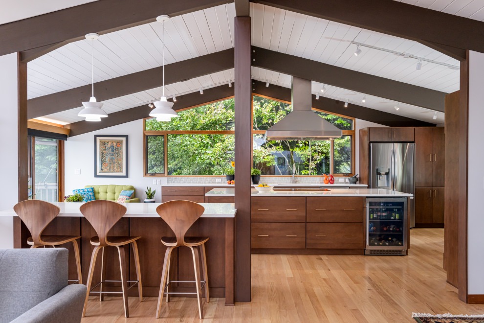 Mid-sized midcentury open plan kitchen in Other with an undermount sink, flat-panel cabinets, brown cabinets, quartz benchtops, green splashback, mosaic tile splashback, stainless steel appliances, light hardwood floors, with island, beige floor, white benchtop and exposed beam.
