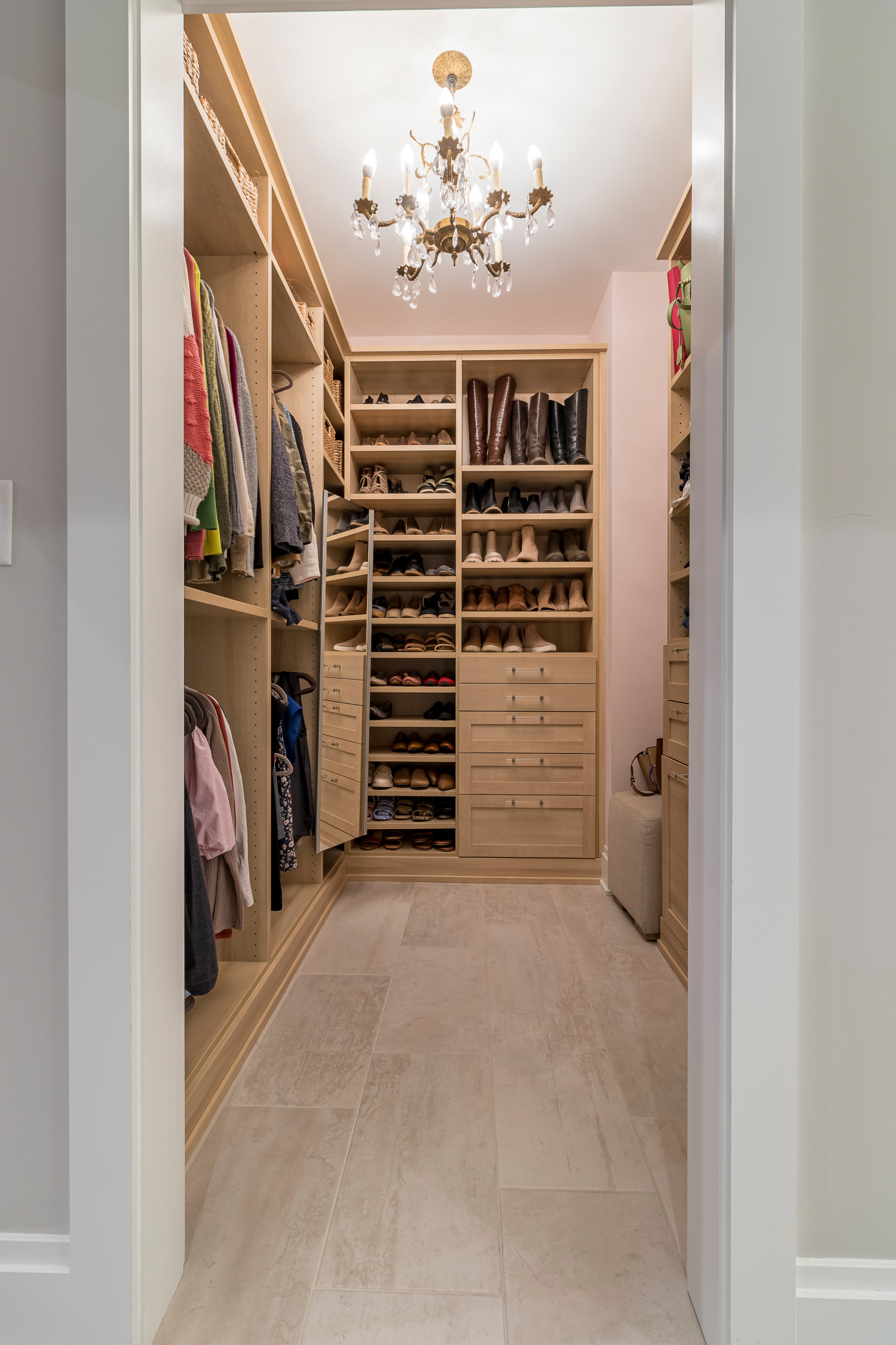 Inspiration for a farmhouse gender-neutral ceramic tile and gray floor walk-in closet remodel in Chicago with open cabinets and light wood cabinets
