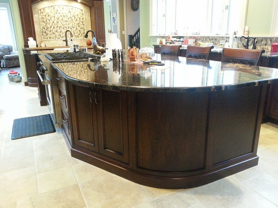 Inspiration for a mid-sized transitional l-shaped ceramic tile enclosed kitchen remodel in Grand Rapids with recessed-panel cabinets, dark wood cabinets, granite countertops, beige backsplash, stainless steel appliances and an island