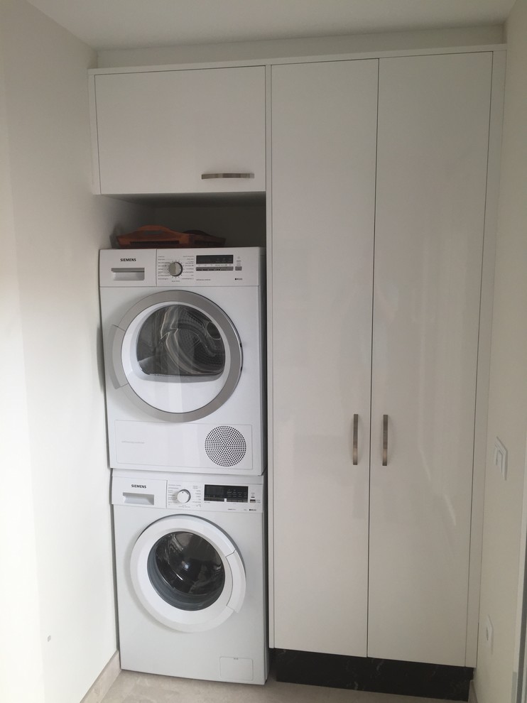 This is an example of a small transitional single-wall laundry cupboard in Other with flat-panel cabinets, white cabinets and white walls.