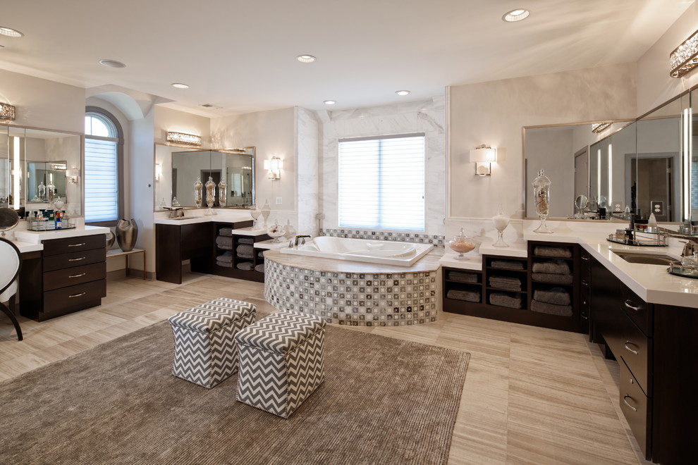 This is an example of a large contemporary master bathroom in DC Metro with flat-panel cabinets, black cabinets, a drop-in tub, white tile, marble, beige walls, porcelain floors, an undermount sink, solid surface benchtops, beige floor and white benchtops.