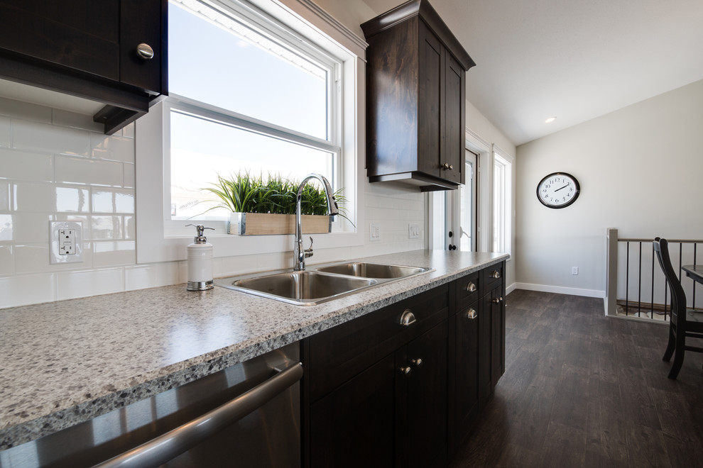Open concept kitchen - mid-sized transitional l-shaped open concept kitchen idea with shaker cabinets, dark wood cabinets, laminate countertops, stainless steel appliances and an island