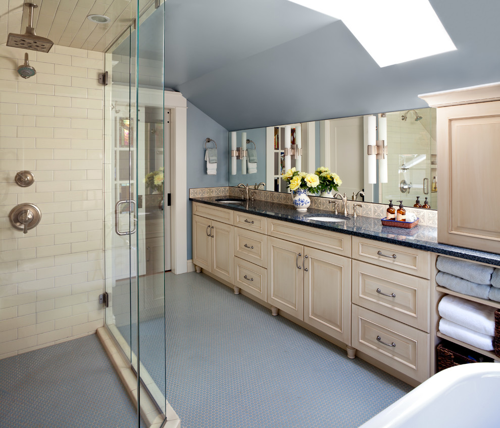This is an example of a mid-sized transitional master bathroom in Denver with an undermount sink, light wood cabinets, granite benchtops, a freestanding tub, an open shower, white tile, subway tile, blue walls, mosaic tile floors, raised-panel cabinets and a hinged shower door.