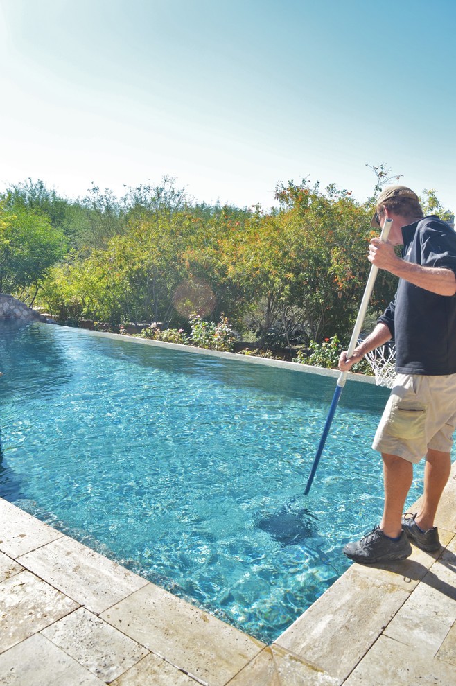 Idées déco pour une piscine arrière classique de taille moyenne et sur mesure avec un point d'eau et des pavés en pierre naturelle.