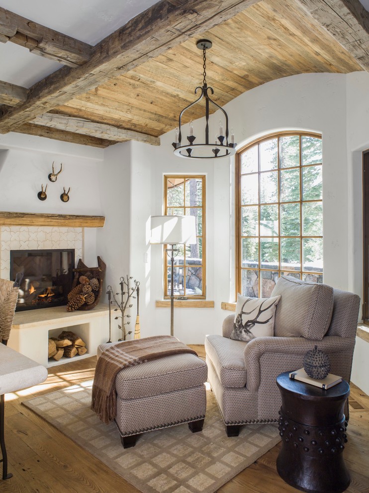 Country living room in San Francisco with white walls, medium hardwood floors, a standard fireplace and a tile fireplace surround.