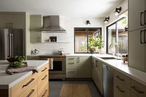 Compact kitchen with sage green flat-panel RTA cabinets, black hardware, quartz counters, and a large corner window
