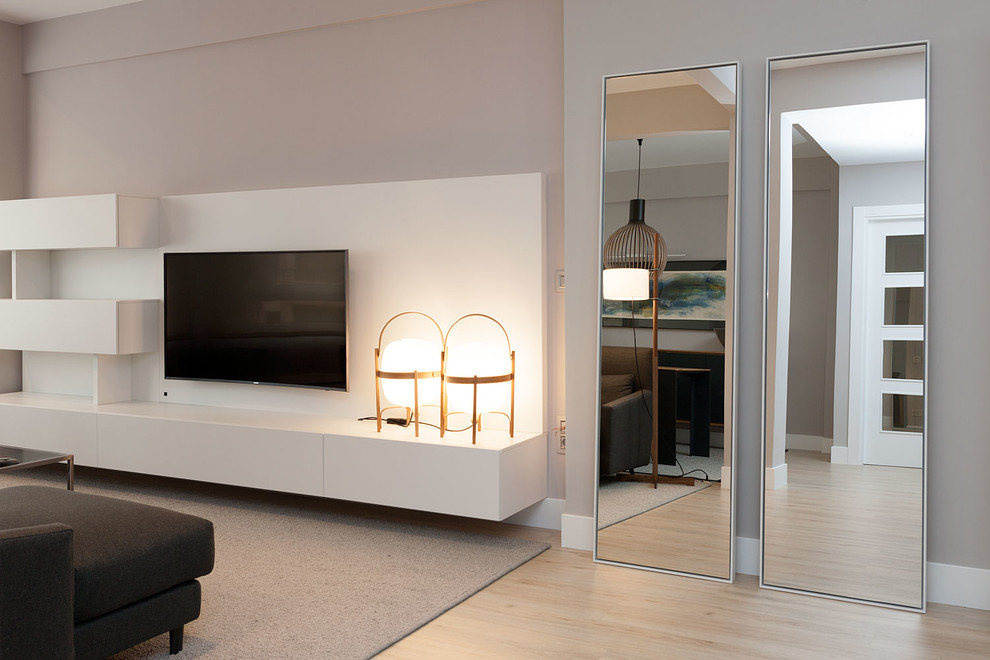 Inspiration for a mid-sized contemporary formal open concept living room in Bilbao with grey walls, light hardwood floors, a concealed tv and no fireplace.