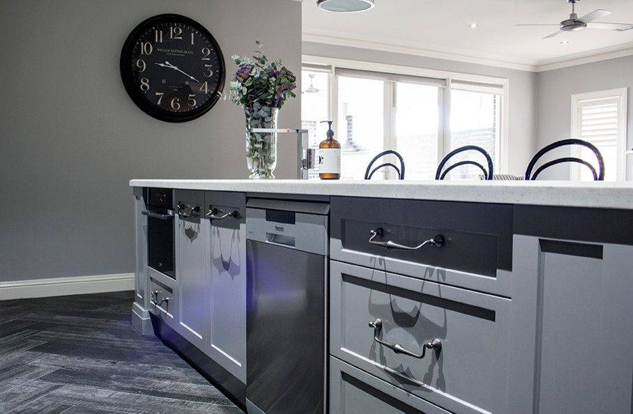 Beach style galley kitchen pantry in Sydney with an undermount sink, shaker cabinets, green cabinets, soapstone benchtops, beige splashback, black appliances, ceramic floors and multiple islands.