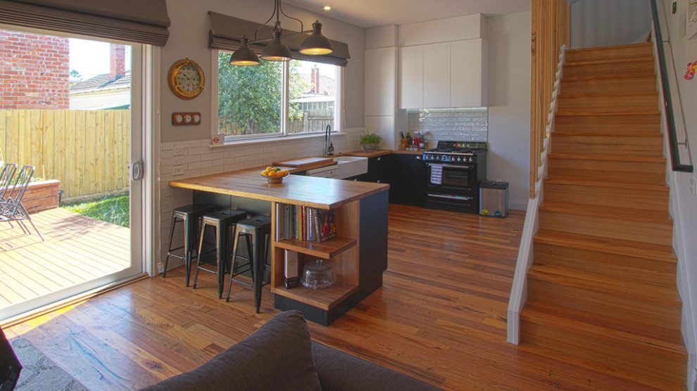 Cette photo montre une cuisine tendance avec un plan de travail en bois et un sol en bois brun.