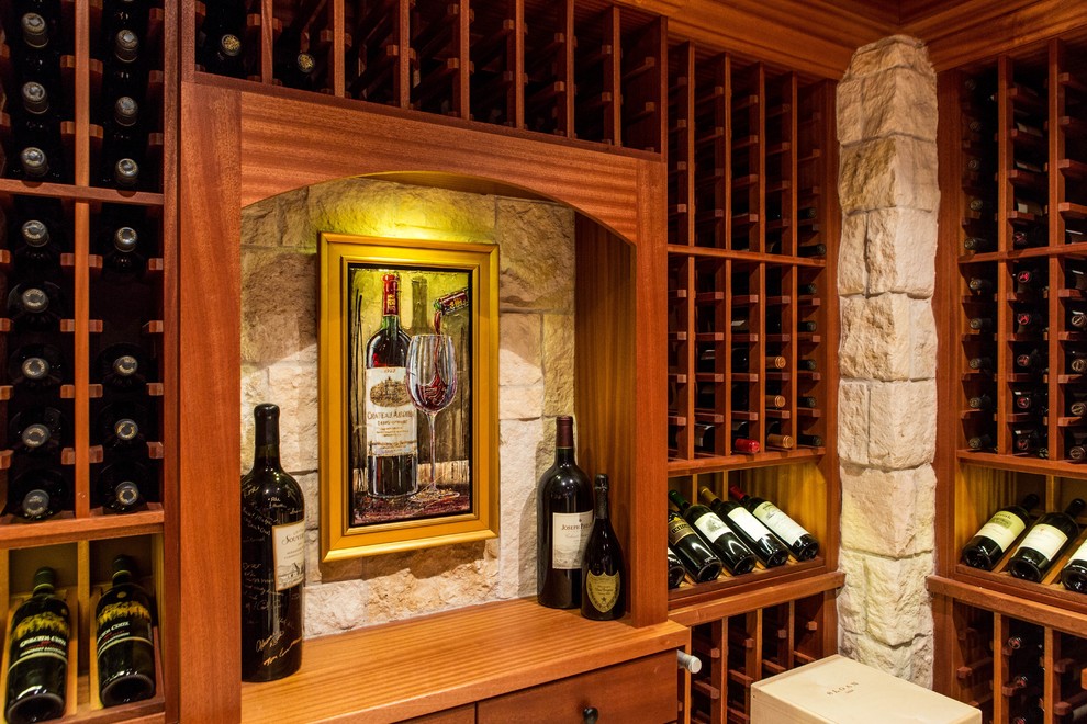 Photo of a traditional wine cellar in Boston with limestone floors and display racks.