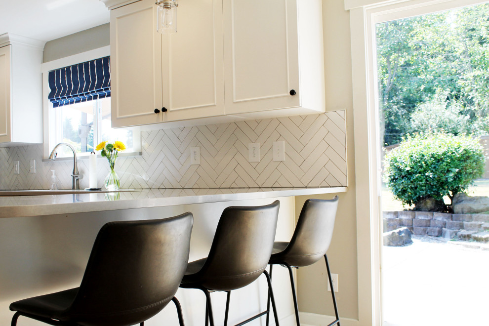 Eat-in kitchen - mid-sized transitional u-shaped medium tone wood floor eat-in kitchen idea in Seattle with an undermount sink, shaker cabinets, white cabinets, quartz countertops, white backsplash, ceramic backsplash, stainless steel appliances, a peninsula and gray countertops