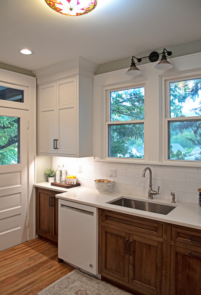 Enclosed kitchen - small transitional light wood floor and brown floor enclosed kitchen idea with an undermount sink, shaker cabinets, medium tone wood cabinets, quartz countertops, white backsplash, ceramic backsplash, white appliances, no island and white countertops