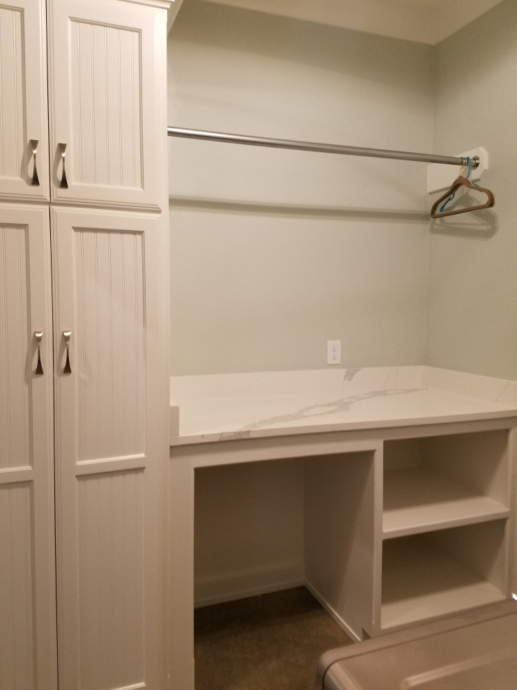 Mid-sized country galley dedicated laundry room in Dallas with beaded inset cabinets, white cabinets, quartzite benchtops, white walls, concrete floors, a side-by-side washer and dryer, grey floor and white benchtop.