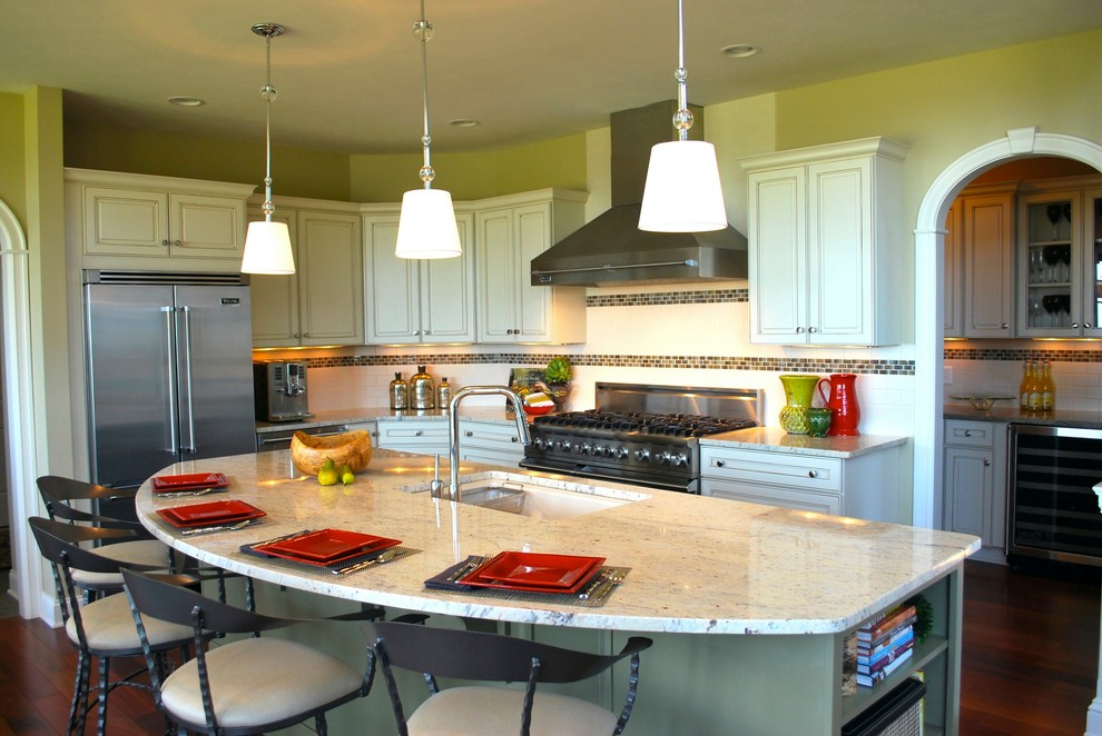 Eat-in kitchen - mid-sized transitional l-shaped medium tone wood floor eat-in kitchen idea in New York with an undermount sink, raised-panel cabinets, white cabinets, granite countertops, white backsplash, ceramic backsplash, stainless steel appliances and an island