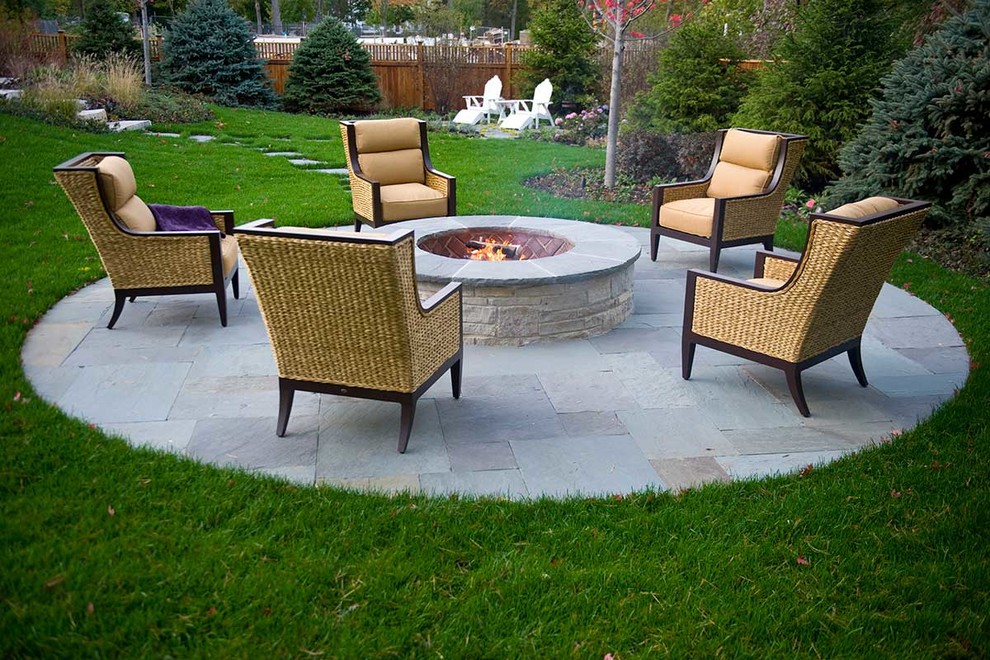 Design ideas for a large traditional backyard patio in Chicago with a fire feature, natural stone pavers and no cover.