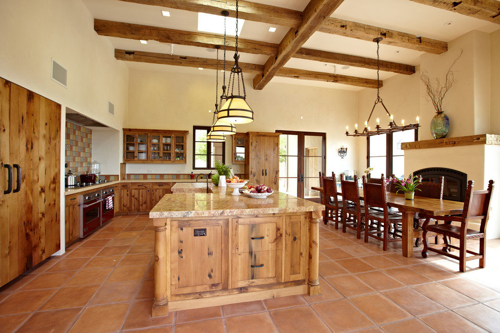 This is an example of an expansive country l-shaped eat-in kitchen in San Francisco with a farmhouse sink, shaker cabinets, medium wood cabinets, granite benchtops, multi-coloured splashback, cement tile splashback, panelled appliances, terra-cotta floors, with island and red floor.