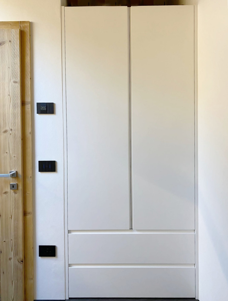 На фото: встроенный шкаф среднего размера, унисекс в современном стиле с плоскими фасадами и белыми фасадами
