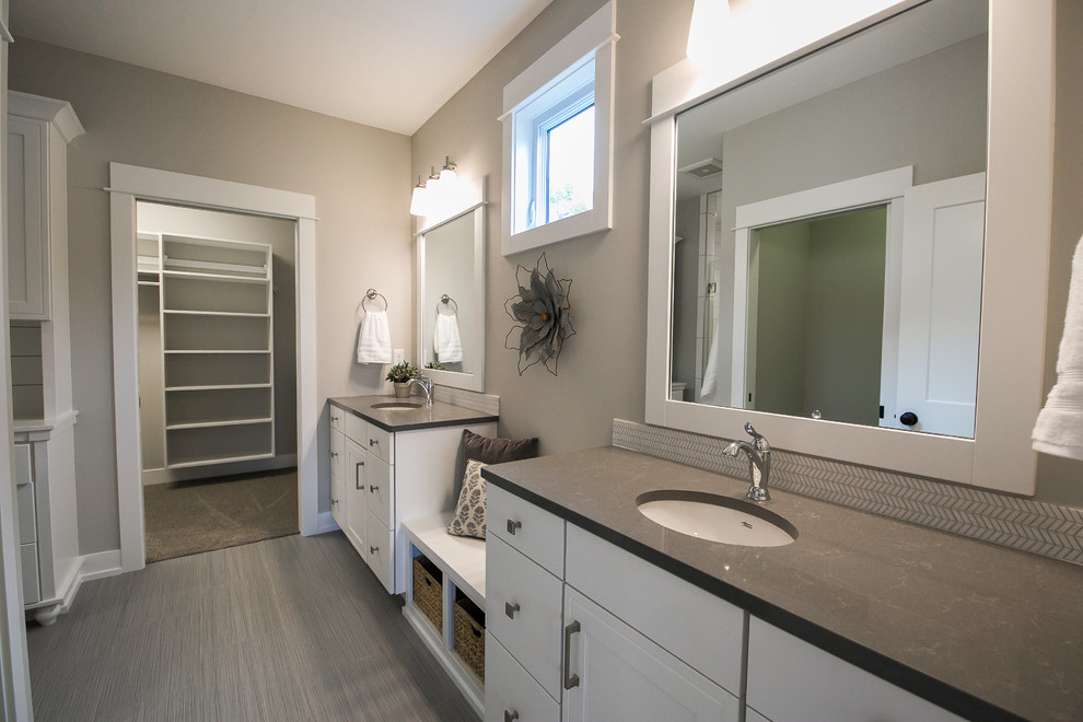 Mid-sized country master bathroom in Grand Rapids with flat-panel cabinets, white cabinets, an alcove shower, a two-piece toilet, gray tile, grey walls, an undermount sink, engineered quartz benchtops, grey floor, a hinged shower door, porcelain floors and grey benchtops.