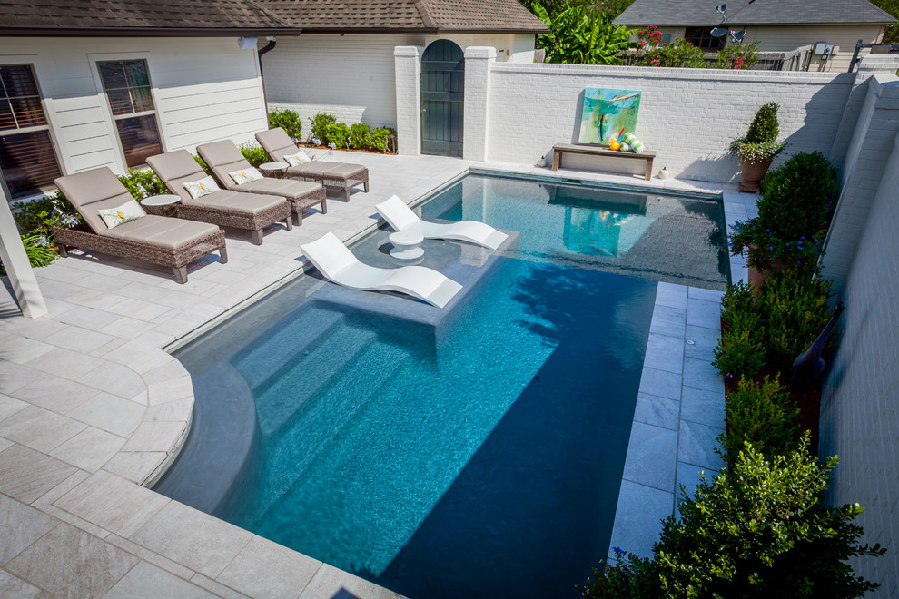 Photo of a mid-sized contemporary backyard custom-shaped lap pool in Houston with a water feature and concrete pavers.