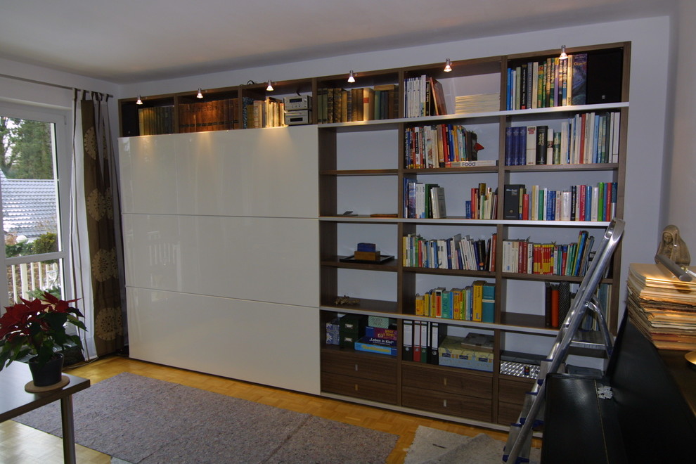 Mittelgroße, Fernseherlose, Abgetrennte Moderne Bibliothek mit weißer Wandfarbe, dunklem Holzboden und braunem Boden in Sonstige