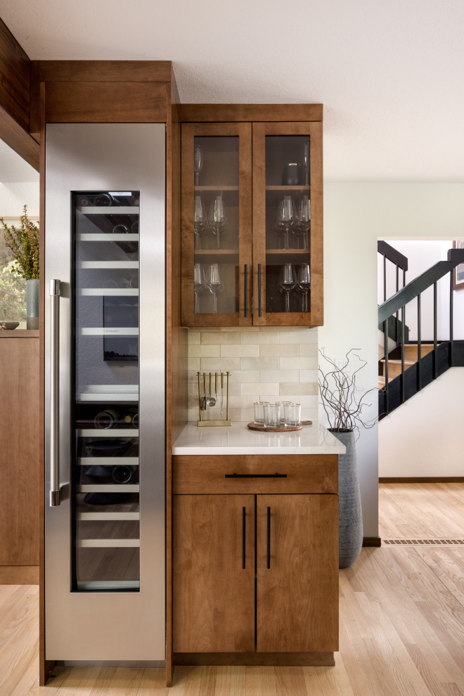 Mid-sized trendy galley medium tone wood floor dry bar photo in Seattle with glass-front cabinets, quartz countertops, beige backsplash, subway tile backsplash and white countertops