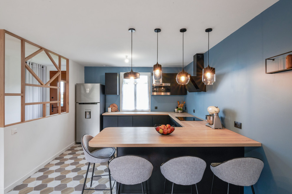 Mid-sized minimalist u-shaped ceramic tile and multicolored floor open concept kitchen photo in Le Havre with flat-panel cabinets, black cabinets, wood countertops, paneled appliances, a peninsula and beige countertops