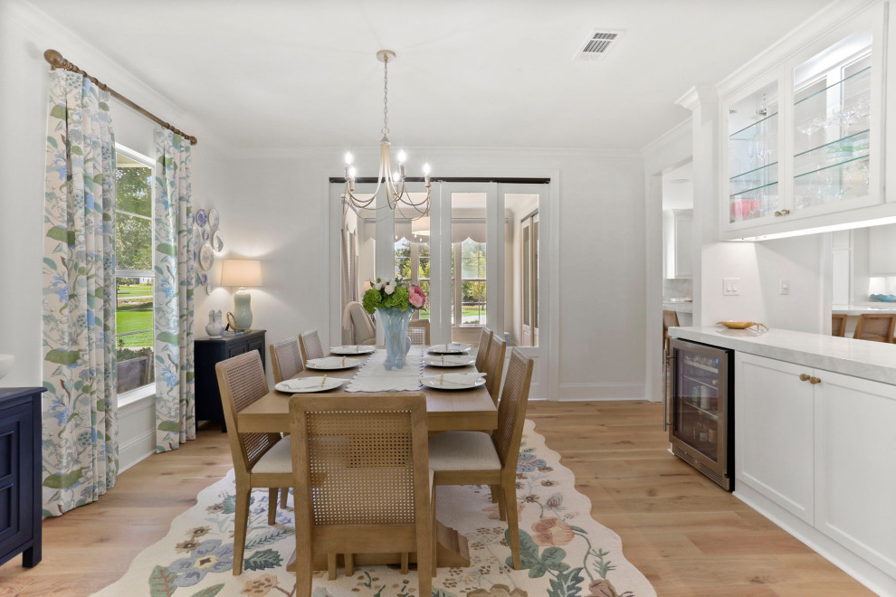 Kitchen/dining room combo - large transitional light wood floor and brown floor kitchen/dining room combo idea in New Orleans with white walls and no fireplace