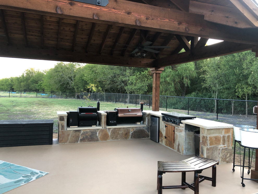 Inspiration for a large country backyard patio in Dallas with an outdoor kitchen, concrete slab and a gazebo/cabana.