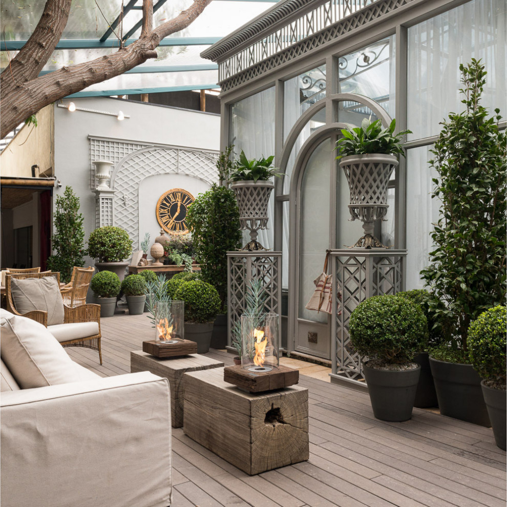 Design ideas for a large traditional balcony in Miami with with fireplace and an awning.