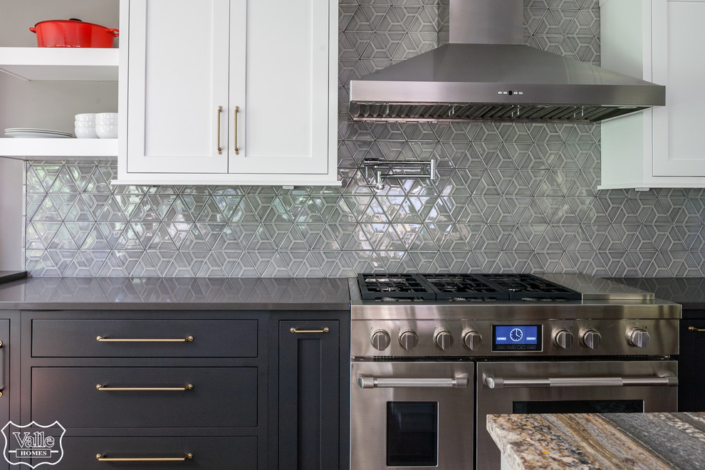 Large transitional u-shaped medium tone wood floor and brown floor eat-in kitchen photo with an undermount sink, shaker cabinets, white cabinets, quartzite countertops, gray backsplash, ceramic backsplash, stainless steel appliances, an island and black countertops