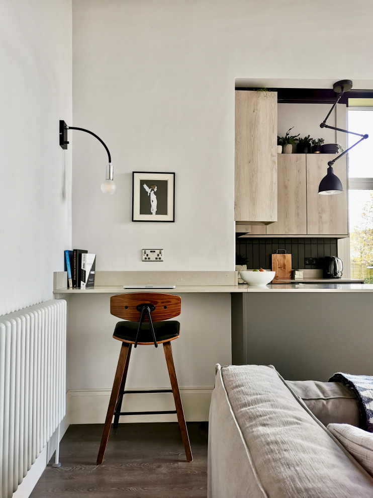 This is an example of a small scandi study in Other with white walls, laminate floors, a built-in desk and brown floors.