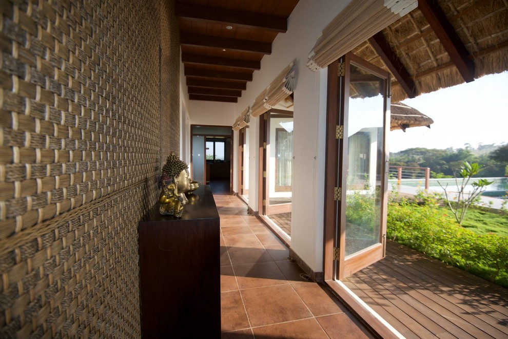 Tropical hallway in Bengaluru with white walls and brown floor.