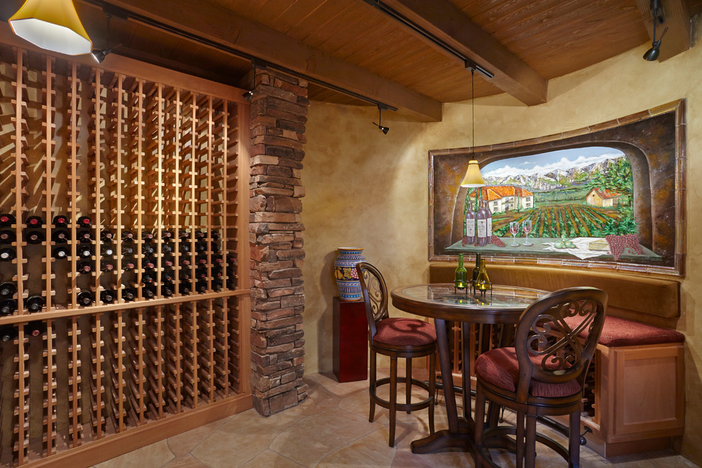 Inspiration for a mediterranean wine cellar in Phoenix with storage racks and beige floor.