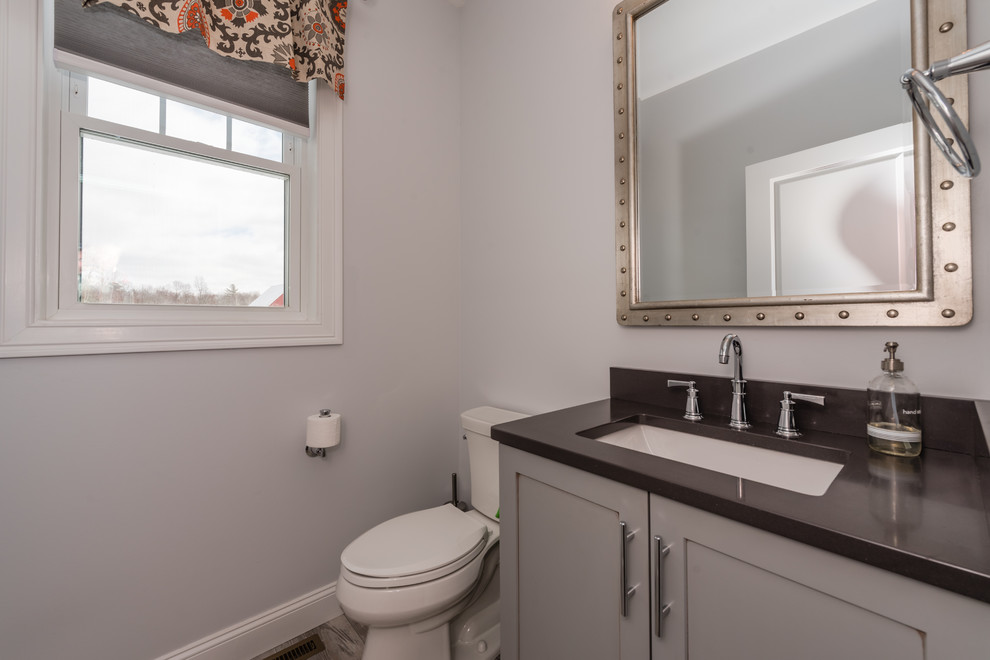 Design ideas for a mid-sized transitional 3/4 bathroom in New York with shaker cabinets, white cabinets, an alcove tub, a shower/bathtub combo, a two-piece toilet, beige tile, stone tile, grey walls, vinyl floors, an undermount sink, quartzite benchtops, beige floor and a shower curtain.